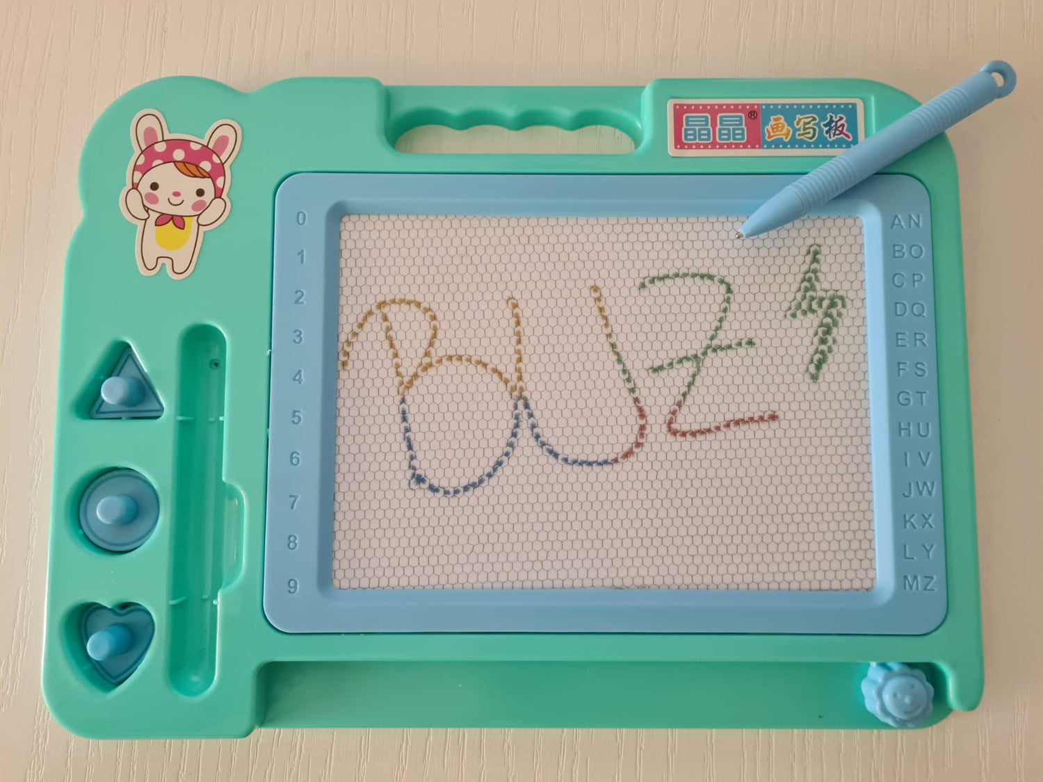 Tablita magnetica, cu stilou, 3 stampile magnetice diferite, cerc, triunghi si inimioara, bara ce sterge scrisul, dimensiune 27x20, culoare roz