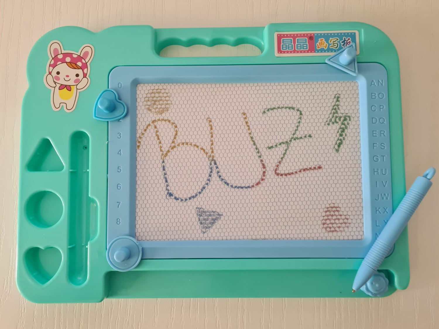 Tablita magnetica, cu stilou, 3 stampile magnetice diferite, cerc, triunghi si inimioara, bara ce sterge scrisul, dimensiune 27x20, culoare roz